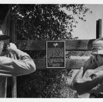 Two (unidentified) members of E. Clampus Vitus photograph a new a plaque commemorating the Sacramento, Placer and Nevada RR, built and operated by Theodore D. Judah in 1961-1864