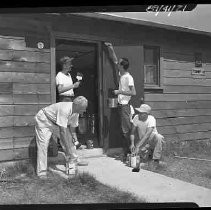 Four unidentified men painting a Boy Scout hall