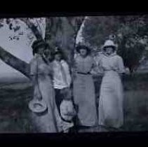 Four unidentified women and a small boy standing under an oak tree