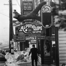 Pedestrian Walks Through Snow and Signage