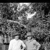 Unknown men standing in front of wagon