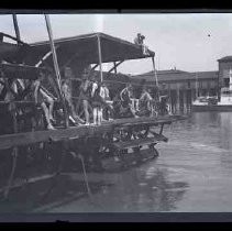 Men sitting on the paddlewheel of a steamboat