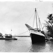 A salvage tug--on the left--tows the "Seamill" from Sherwood Harbor upstream to a new berth