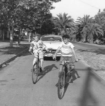 Two boys riding bicycles