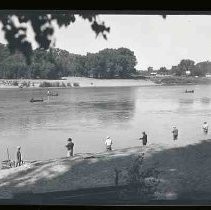 Men fishing from a river bank