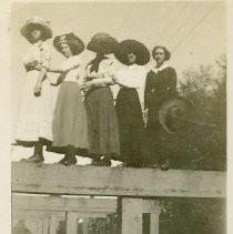 Girls with hats standing on beams