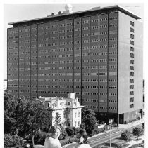 Two women looking at Stanford Home in foreground with State Water Resources Building in background
