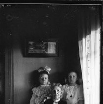 Older woman and two young girls in window