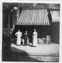 View next door to Pioneer Hall at 1007 7th Street. View shows Mr. and Mrs. Miller in front of their business