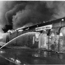 Firefighters work to extinguish the flames engulfing the Exposition Hall at the old state fair grounds on Stockton Blvd