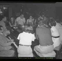 Unidentified people sitting around a piano