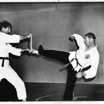 Daryl Gleason (right, a handicapped athlete) shown practicing for chop on 1-inch board