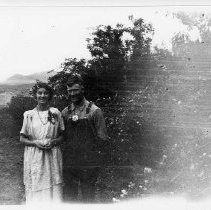 Man and woman in yard with flowers