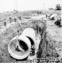 "Laying a Joint of 9' Diameter Pipe Into Trench"