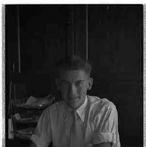 Man seated at desk looking at an album