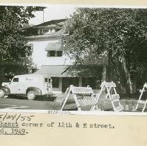 View of the north east corner of 12th & E Streets. Visible is a commercial/residential building with a Dodge delivery van in front. A. Teichert & Son construction barracades