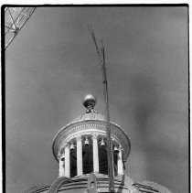 View of a workman guiding rebar through the California State Capitol dome. It is to be used to re-inforce the upper drum wall of the rotunda. It will be shot-creted, a cementing process