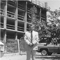 Man poses in front of building under construction