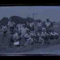 Amateur baseball teams posed in a field