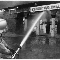 Firefighters work to extinguish the flames engulfing the Exposition Hall at the old state fair grounds on Stockton Blvd