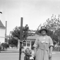 Woman with girl child in front of newly planted tree