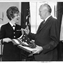 Harold T. "Bizz" Johnson, California state senator (1948-1958) and U.S. Congressman (1958-1981). Here, he presents a flag that has flown over the capitol to Navy Captain and WAVE commander Robin L. Quigley