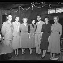 A group of people standing in a kitchen