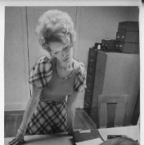 Eileen Kuster waits while unidentified man checks through records