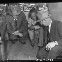 Three men playing dice in Myers Jewelry store