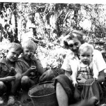 Three children with woman outdoors