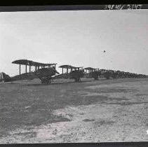 A long line of bi-wing airplanes parked