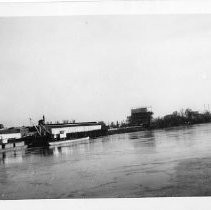 View of the Sacramento River during flood stage in 1935. This image is looking south from the M Street Bridge. Sacramento is on the left