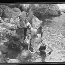 Children and adults playing and swimming in a river