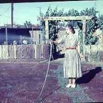 Woman watering a back yard