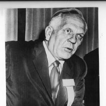 Goodwin Knight, Governor of California from 1953-1959. Here, he holds onto chair as he talks with reporters