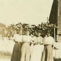 Four women by a barn