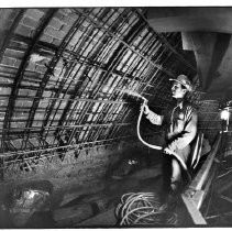 View of Pat Wymore a laborer, wets down steel re-inforced brick rotunda of the California State Capitol building