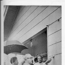 Here, Mayor Marriott (center) helps paint a house in Oak Park as several people watch