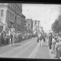 Two men on horseback carrying American flags