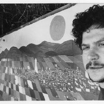 John Doerper shown with mural he painted on a G Street bulletin board as a public service to the City of Davis