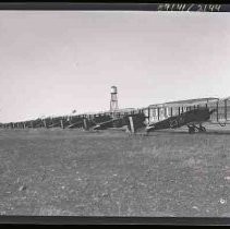 A long line of bi-wing airplanes parked
