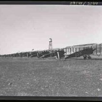 A long line of bi-wing airplanes parked