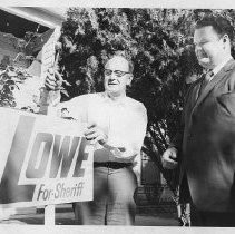 Duane Lowe with a supporter, putting up a Lowe for Sheriff lawn sign
