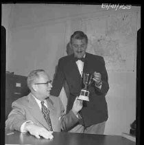 Two men holding a trophy