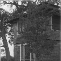 Exterior view of a woman sitting in front of a house