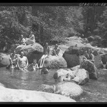 Children and adults playing and swimming in a river