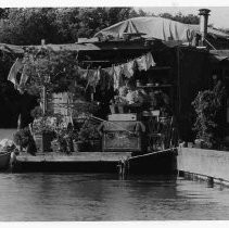 Houseboat-View of a houseboat with family on board on a river