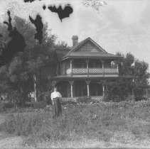 Exterior view of a home, possibly N. R. Smith's residence in Fair Oaks. Woman is unknown