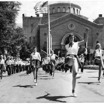 View of a marching band in front of the old California State Fair grounds at Stockton and Broadway