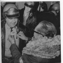 President of San Francisco State, Dr. S.I. Hayakawa, pins a flower on Sgt. Edward Levine of the Marin County Sheriff's Dept., which assisted in keeping order during SF State protests